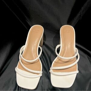 Strappy white wedge heel sandal.